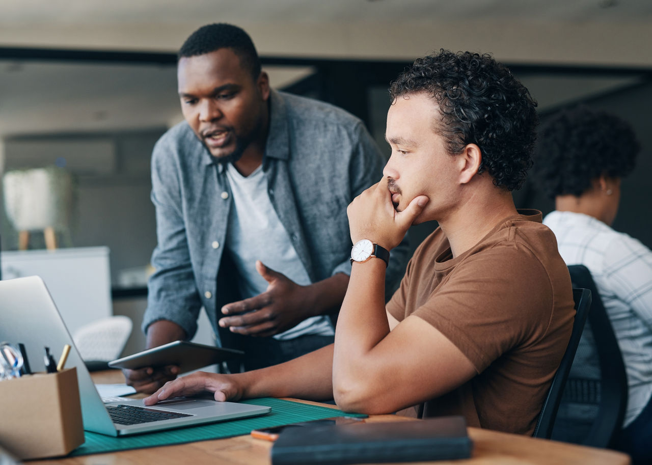 Shot of two young businessmen working together in an office.