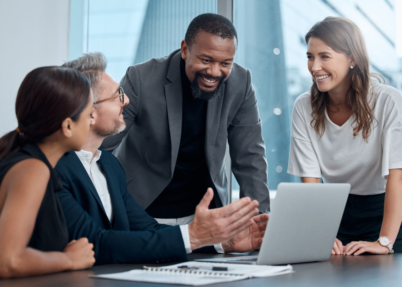 Financial workers discussing business over laptop in office